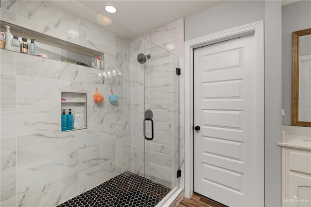 bathroom featuring walk in shower and vanity