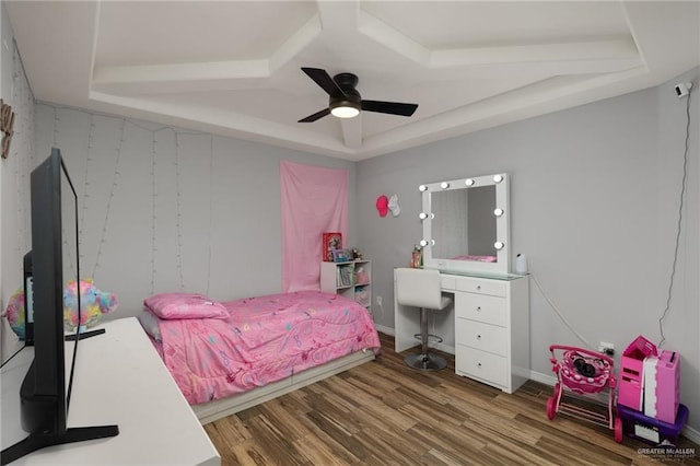 bedroom with ceiling fan, wood-type flooring, and a tray ceiling