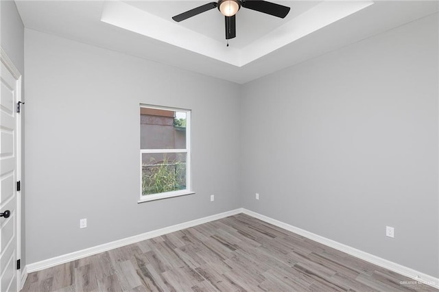 814 N Martinez Ave, Weslaco, TX 78596 - unfurnished room with wood finished floors, a tray ceiling, ceiling fan, and baseboards