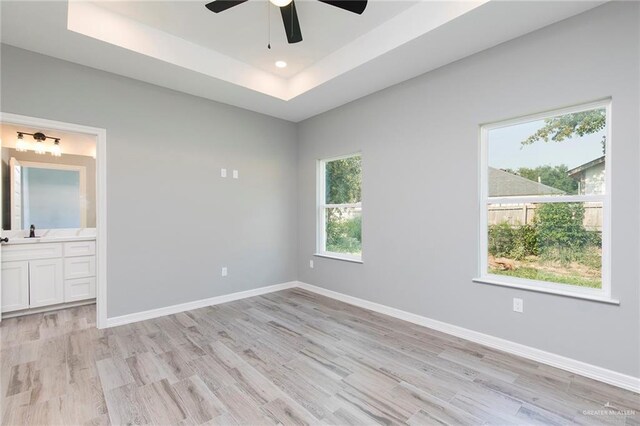 814 N Martinez Ave, Weslaco, TX 78596 - empty room featuring light wood-style flooring, a ceiling fan, baseboards, a tray ceiling, and recessed lighting