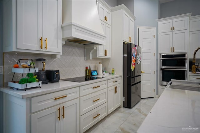 kitchen featuring premium range hood, white cabinetry, black appliances, and light stone counters