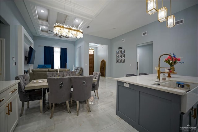 dining space with coffered ceiling, crown molding, sink, an inviting chandelier, and beamed ceiling