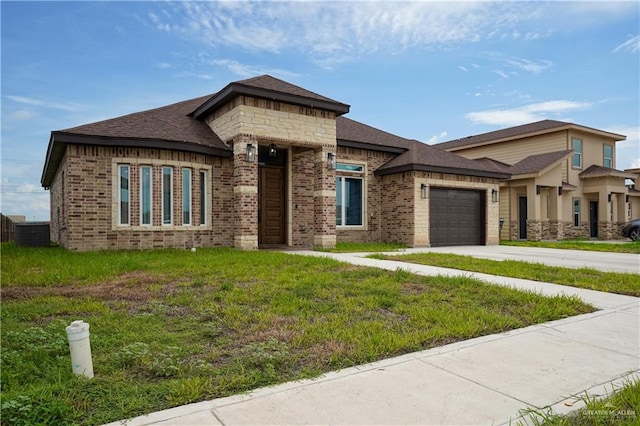 prairie-style house featuring a garage and a front lawn