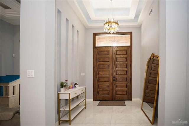 entrance foyer featuring an inviting chandelier and a tray ceiling