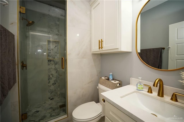 bathroom with a shower with door, vanity, and toilet