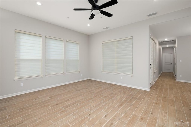 unfurnished room featuring visible vents, light wood-style flooring, and baseboards