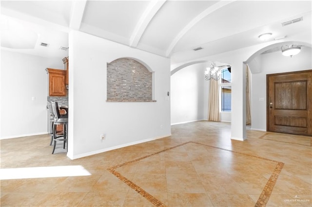 foyer entrance with light tile patterned floors, vaulted ceiling with beams, and a notable chandelier