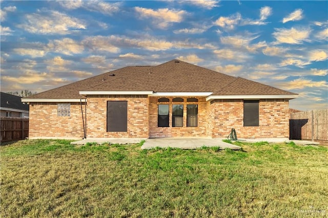 back of property with a patio area and a yard