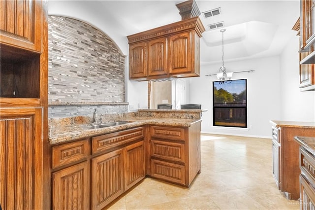 kitchen featuring an inviting chandelier, sink, light tile patterned flooring, light stone counters, and kitchen peninsula