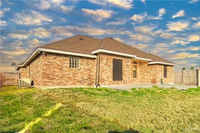 back of property with a yard, cooling unit, and a patio area