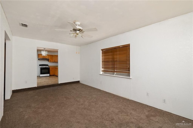 empty room featuring ceiling fan and dark carpet