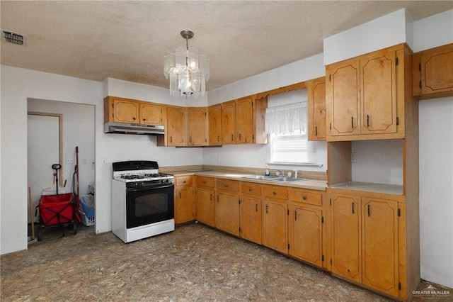 kitchen with gas range gas stove, a textured ceiling, sink, decorative light fixtures, and a notable chandelier