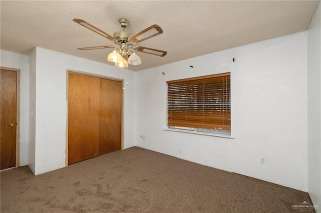 unfurnished bedroom with carpet, ceiling fan, a textured ceiling, and a closet