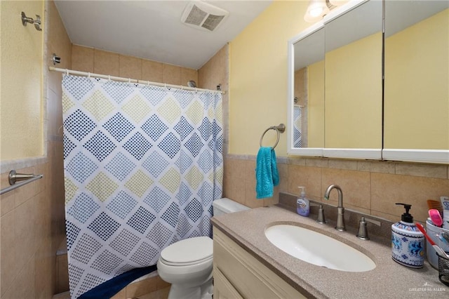 bathroom with toilet, vanity, tile walls, and walk in shower