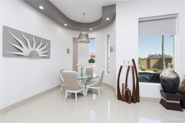 tiled dining room featuring a healthy amount of sunlight and a notable chandelier