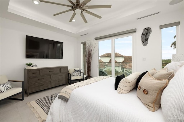 bedroom featuring access to exterior, ceiling fan, and a raised ceiling