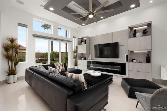 living room featuring ceiling fan and a high ceiling