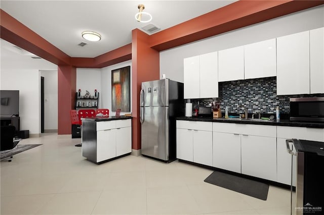 kitchen with decorative backsplash, appliances with stainless steel finishes, white cabinets, and sink