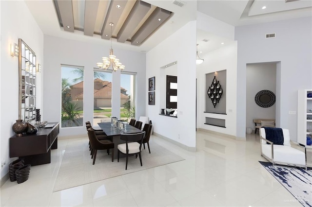 dining area featuring a towering ceiling, an inviting chandelier, and light tile patterned flooring