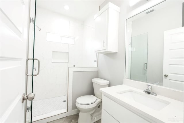 bathroom with vanity, a shower with shower door, and toilet