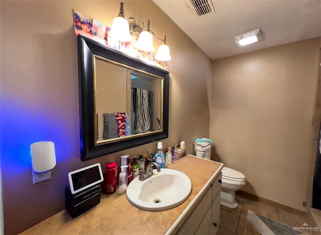 bathroom with vanity, tile patterned flooring, toilet, and a textured ceiling