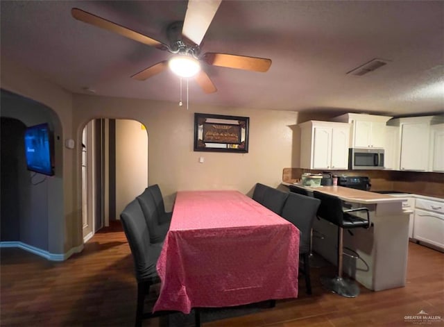 dining space with dark hardwood / wood-style floors and ceiling fan