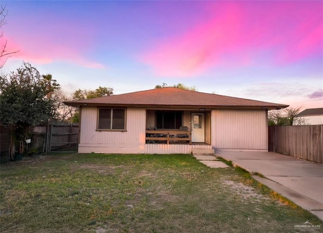 back house at dusk with a lawn