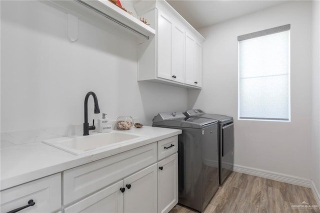1806 E 28th St, Mission, TX 78574 - laundry area featuring cabinet space, washing machine and clothes dryer, light wood-type flooring, and baseboards