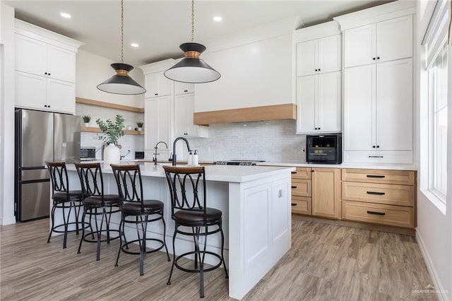 1806 E 28th St, Mission, TX 78574 - kitchen with freestanding refrigerator, light countertops, a center island with sink, decorative backsplash, and open shelves