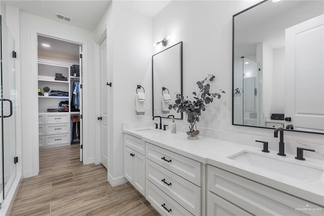 1806 E 28th St, Mission, TX 78574 - bathroom with double vanity, a shower stall, wood finished floors, and a walk in closet