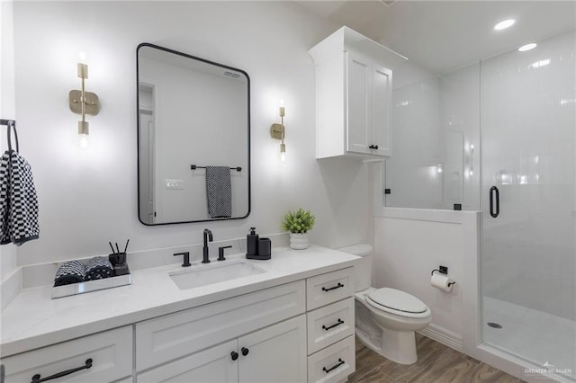 1806 E 28th St, Mission, TX 78574 - bathroom featuring toilet, vanity, a stall shower, and wood finished floors