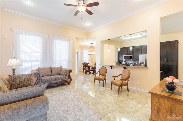 living room with ornamental molding, a healthy amount of sunlight, baseboards, and a ceiling fan