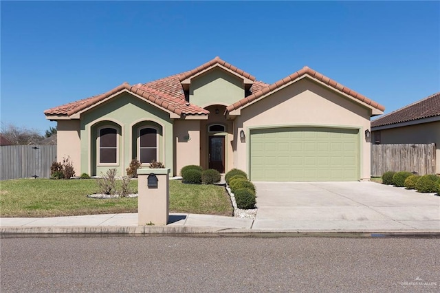 mediterranean / spanish house with a garage, fence, concrete driveway, and a front yard