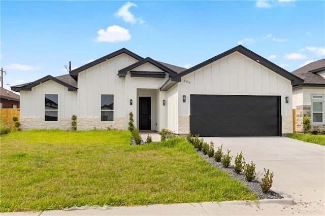 803 Ava Dr, La Feria, TX 78559 - modern inspired farmhouse with board and batten siding, an attached garage, a front yard, driveway, and stone siding