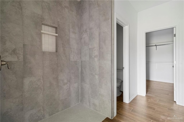 803 Ava Dr, La Feria, TX 78559 - full bathroom featuring toilet, wood finished floors, and tiled shower
