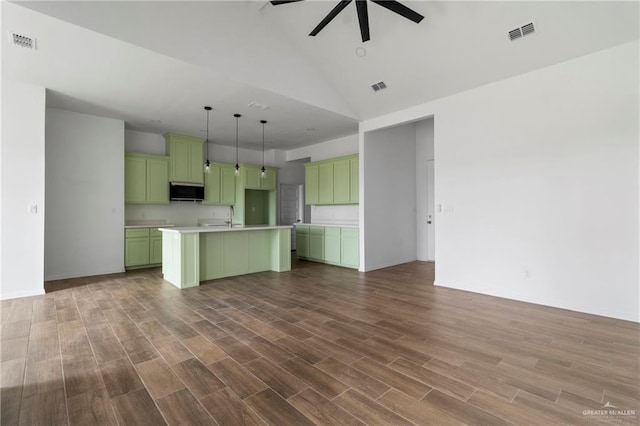 803 Ava Dr, La Feria, TX 78559 - kitchen with green cabinets, a ceiling fan, open floor plan, a kitchen island with sink, and wood finished floors
