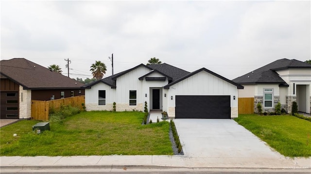 803 Ava Dr, La Feria, TX 78559 - view of front of home with a garage, board and batten siding, concrete driveway, and stone siding