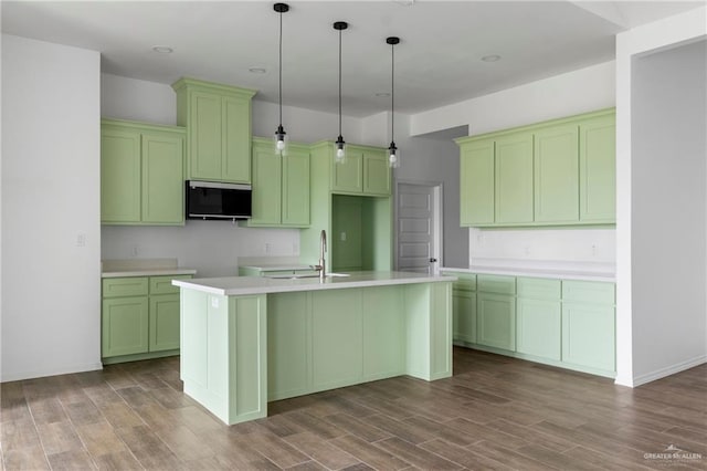 803 Ava Dr, La Feria, TX 78559 - kitchen featuring a sink, stainless steel microwave, a kitchen island with sink, wood finished floors, and recessed lighting