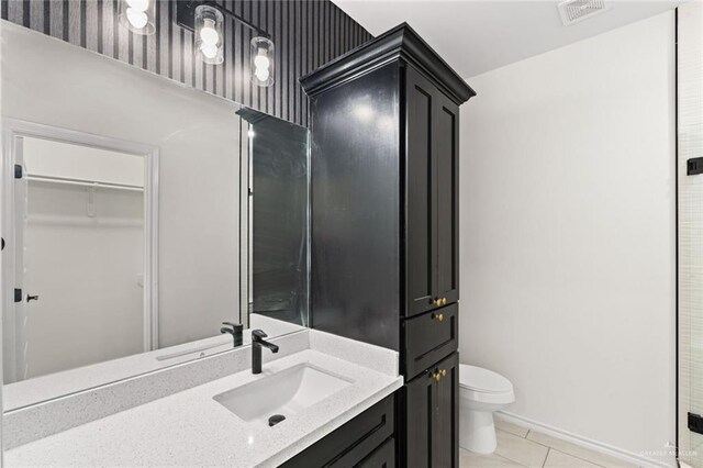 412 Leon Ave, Elsa, TX 78542 - bathroom with tile patterned flooring, vanity, and toilet