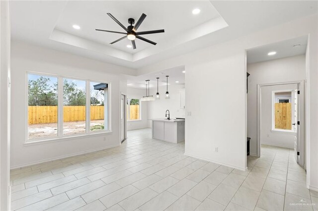 412 Leon Ave, Elsa, TX 78542 - unfurnished living room with a raised ceiling, ceiling fan, and sink