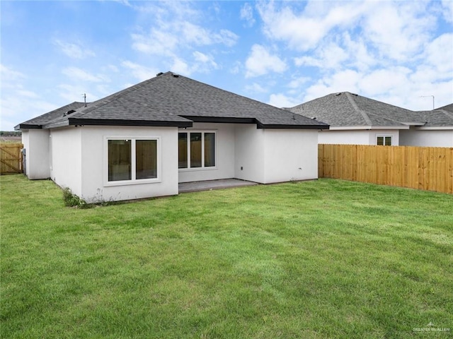 412 Leon Ave, Elsa, TX 78542 - rear view of property featuring a shingled roof, a fenced backyard, and stucco siding