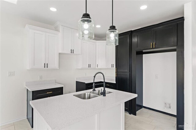 412 Leon Ave, Elsa, TX 78542 - kitchen with white cabinets, sink, hanging light fixtures, and an island with sink