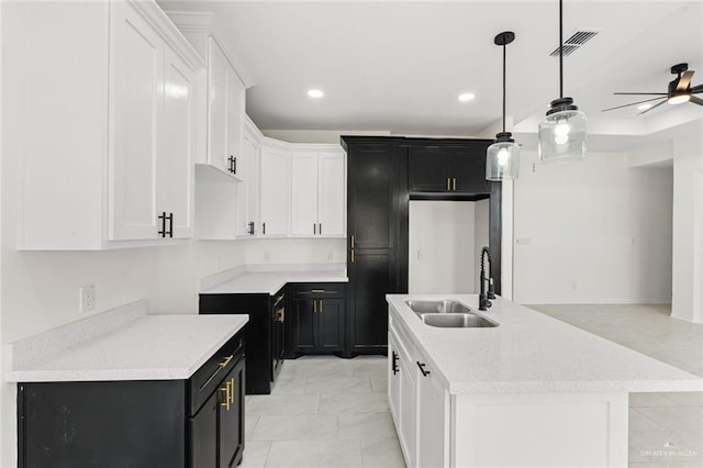 412 Leon Ave, Elsa, TX 78542 - kitchen with dark cabinetry, a kitchen island with sink, ceiling fan, recessed lighting, and white cabinetry