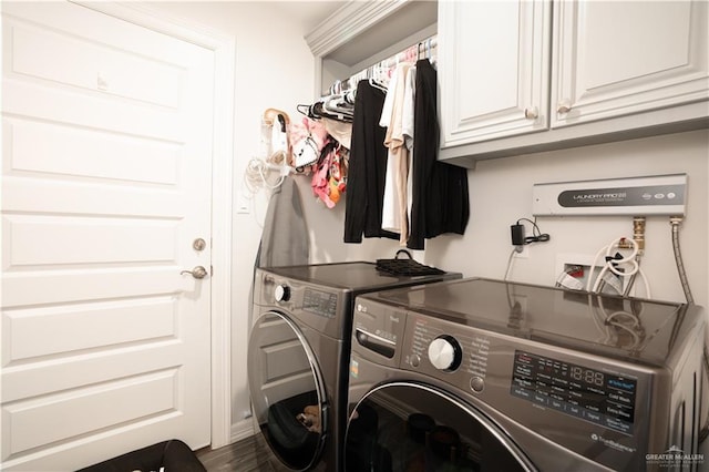 laundry room with cabinets, washing machine and dryer, and dark hardwood / wood-style floors