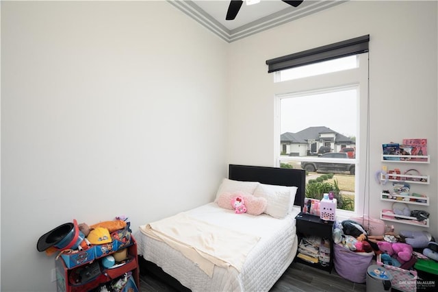 bedroom with multiple windows, dark hardwood / wood-style flooring, ornamental molding, and ceiling fan