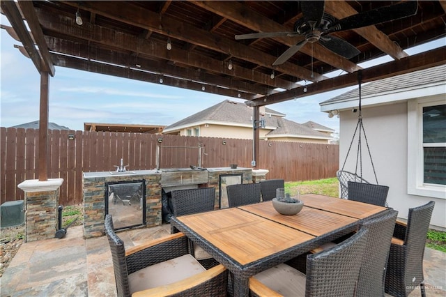 view of patio featuring ceiling fan and sink