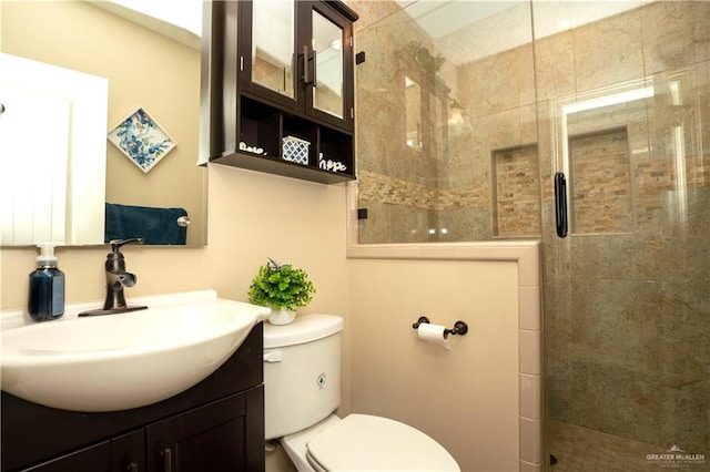 bathroom featuring tiled shower, vanity, and toilet