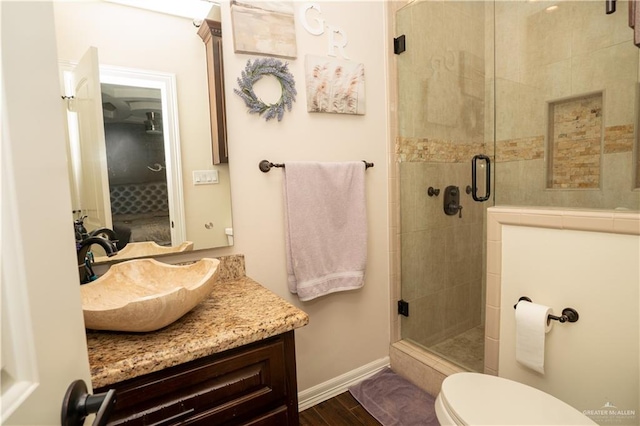 bathroom featuring hardwood / wood-style floors, toilet, an enclosed shower, and vanity