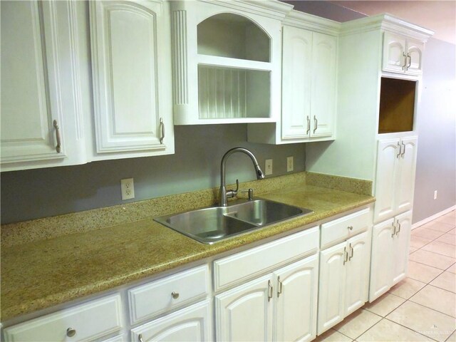 kitchen featuring light tile patterned floors, white cabinetry, and sink