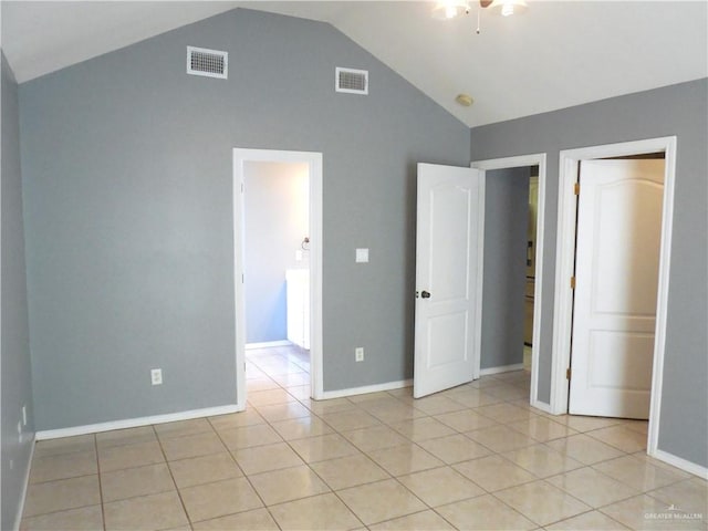 unfurnished bedroom featuring vaulted ceiling and light tile patterned flooring